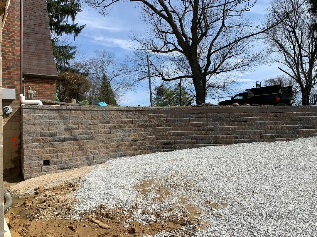 A brick wall is being built in the backyard of a house.