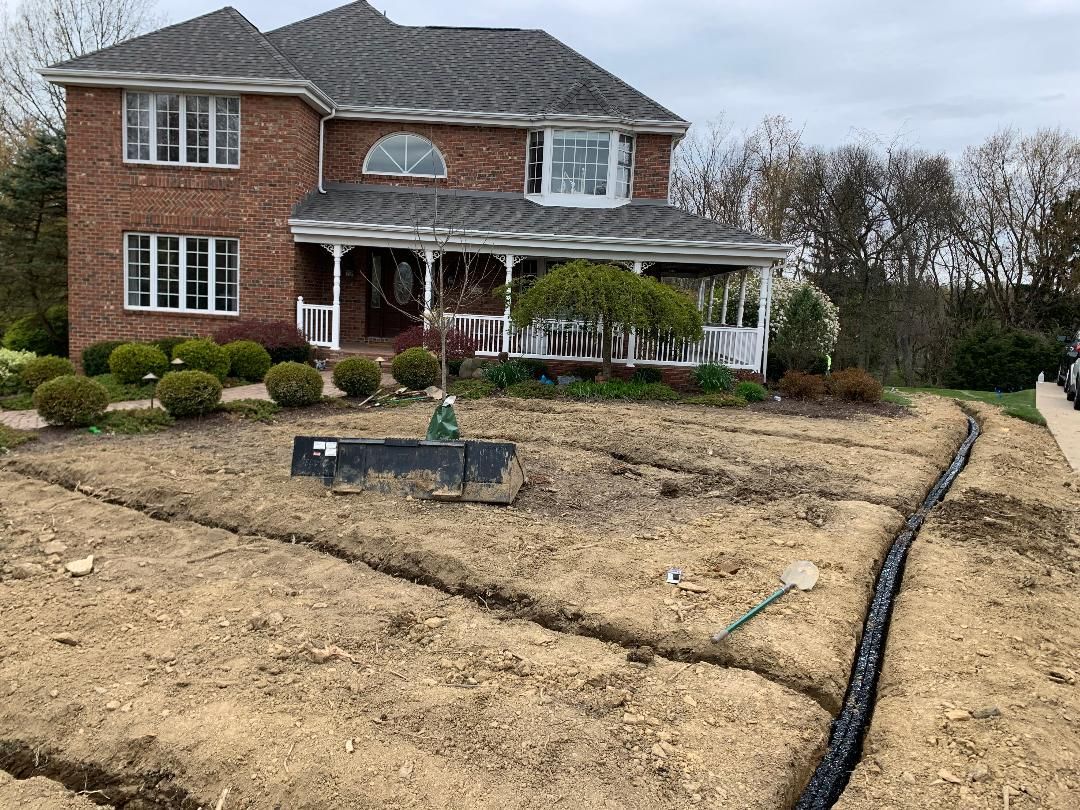 A large brick house with a lot of dirt in front of it.
