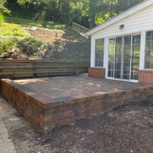 A house with a patio and a brick wall in front of it.