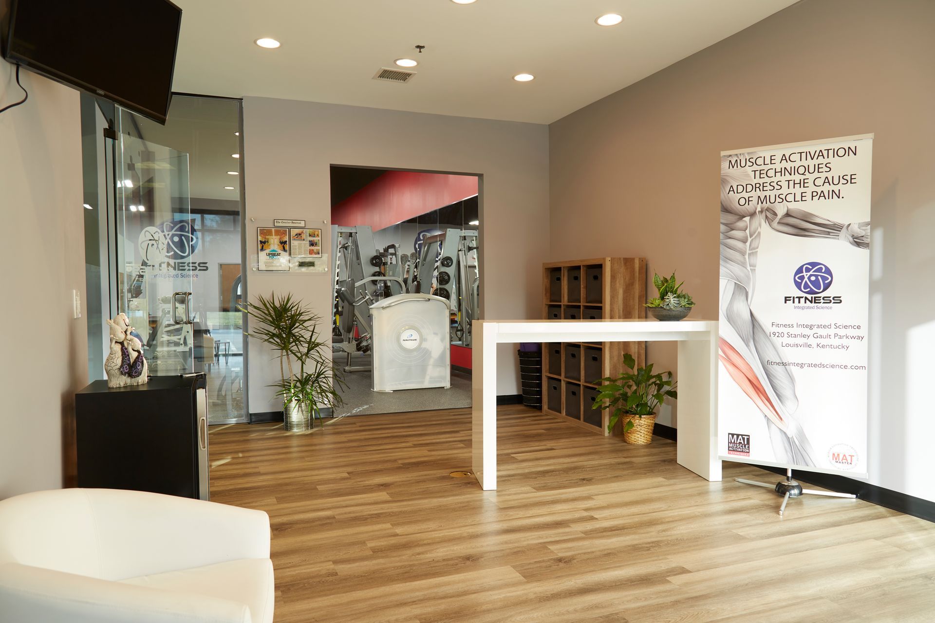 A waiting room with a chair , table , and television.