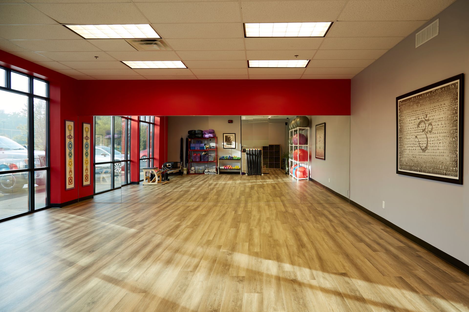 A large empty room with wooden floors and red walls.