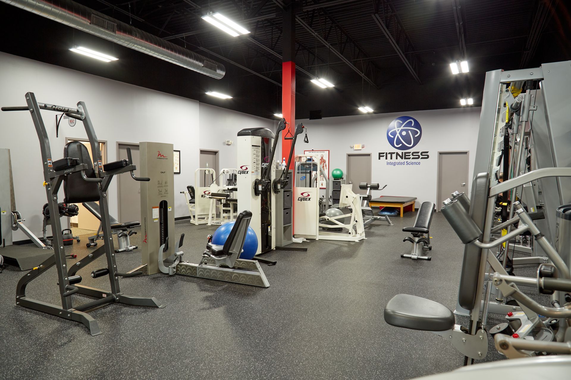 A large gym filled with lots of exercise equipment.