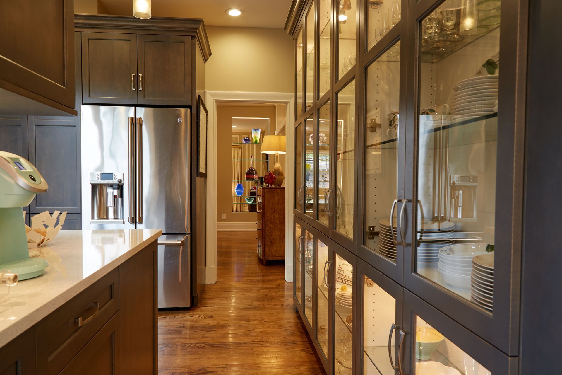 A kitchen with stainless steel appliances and glass cabinets