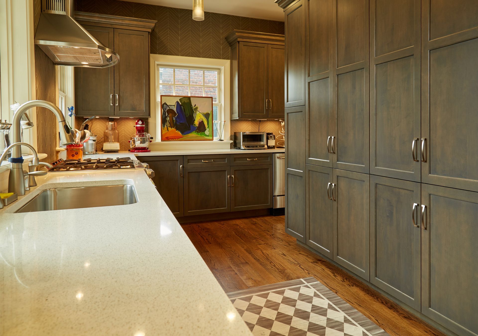 A kitchen with gray cabinets and white counter tops