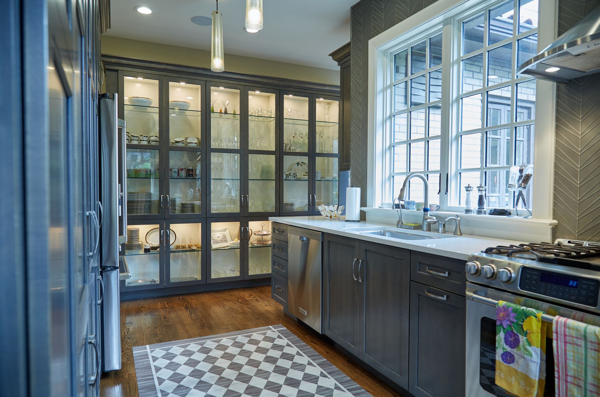 A kitchen with stainless steel appliances and a checkered floor.