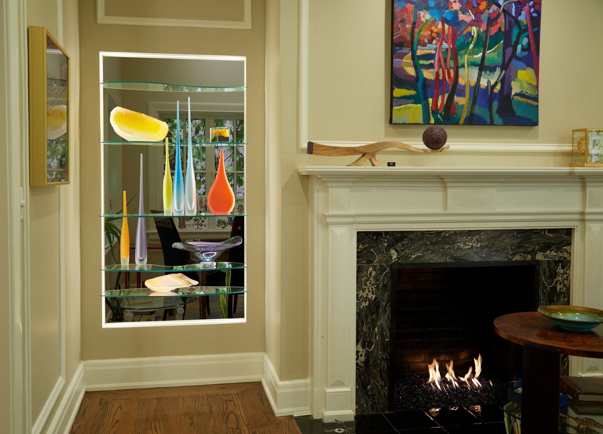 A living room with a fireplace and a painting on the wall