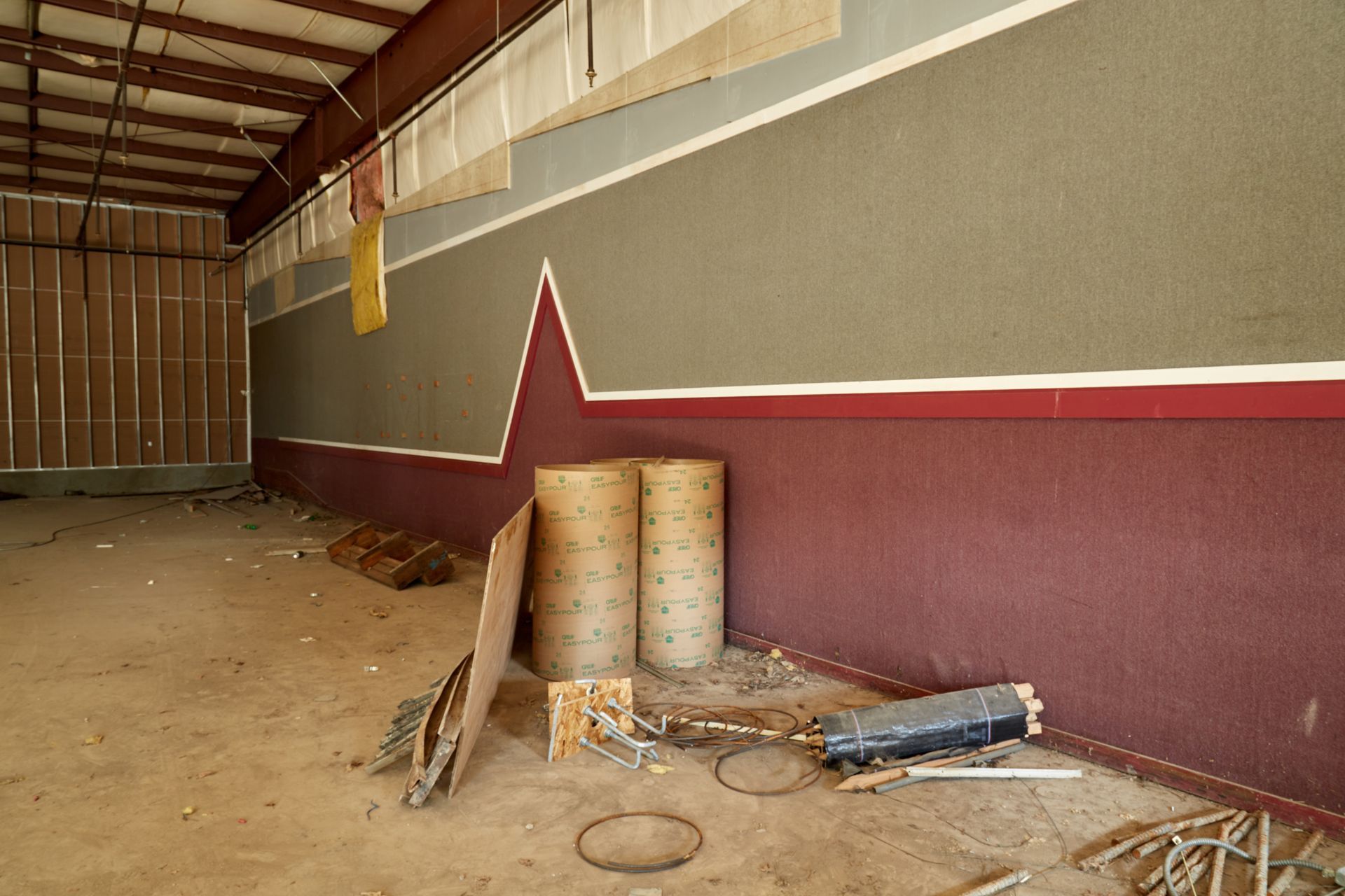 An empty room with a red and white stripe on the wall