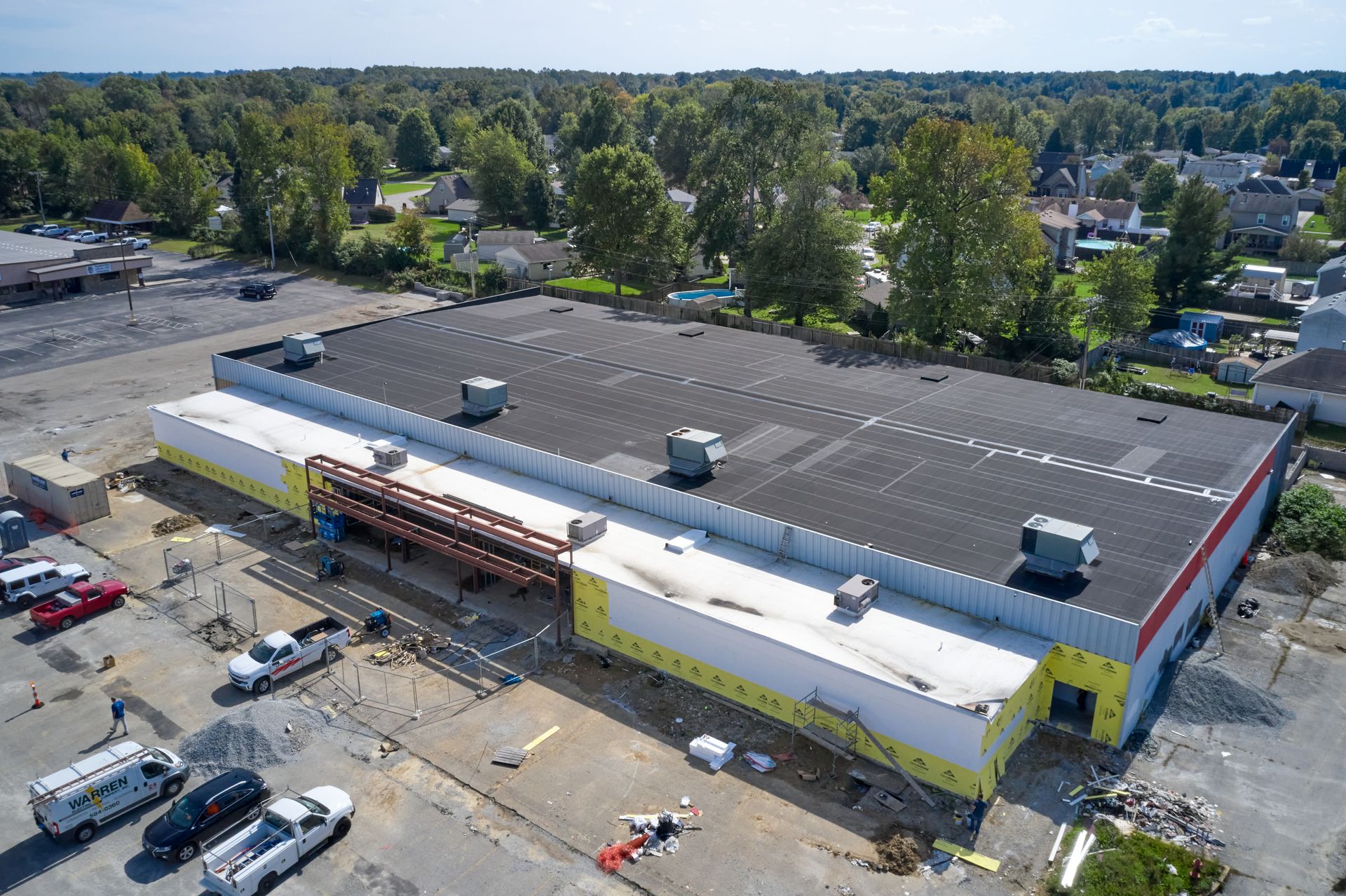 An aerial view of a large building under construction in a parking lot.