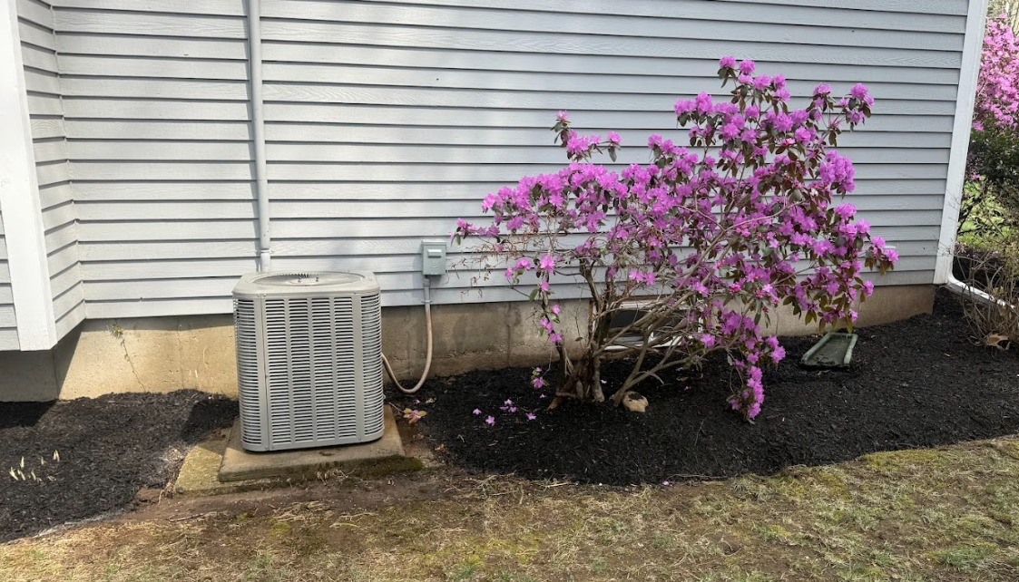 Two air conditioners are sitting outside of a brick building.