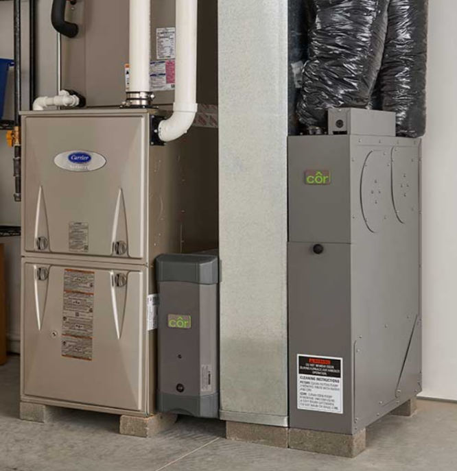 A water heater is sitting in a corner of a room next to a vacuum cleaner.