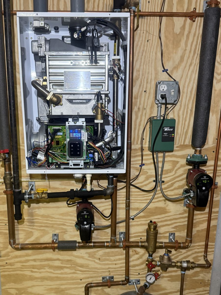 The inside of a boiler with copper pipes attached to it
