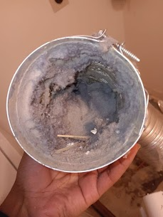 A person is holding a dirty hose in their hand.