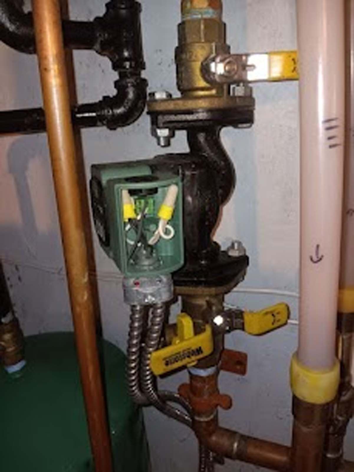 A close up of a copper pipe with a yellow valve on it