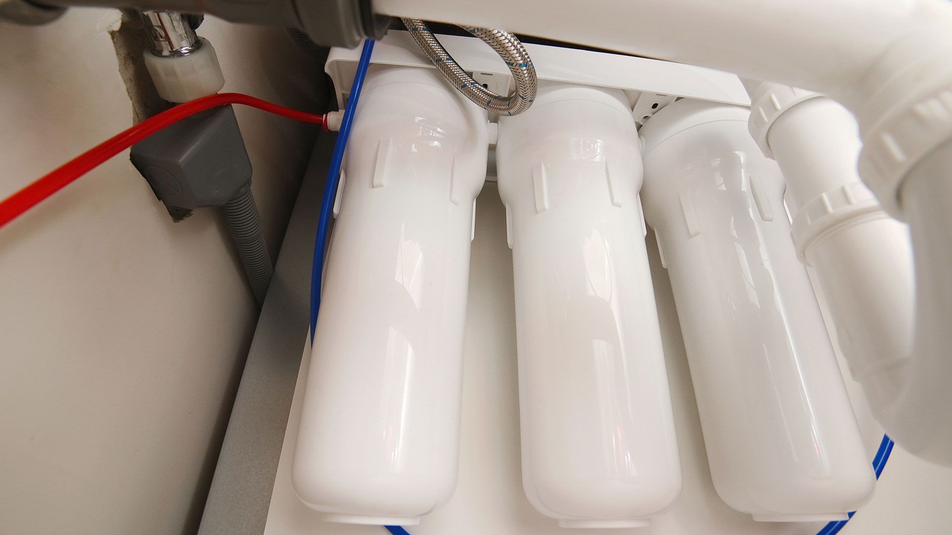 A close up of a water filter under a sink.