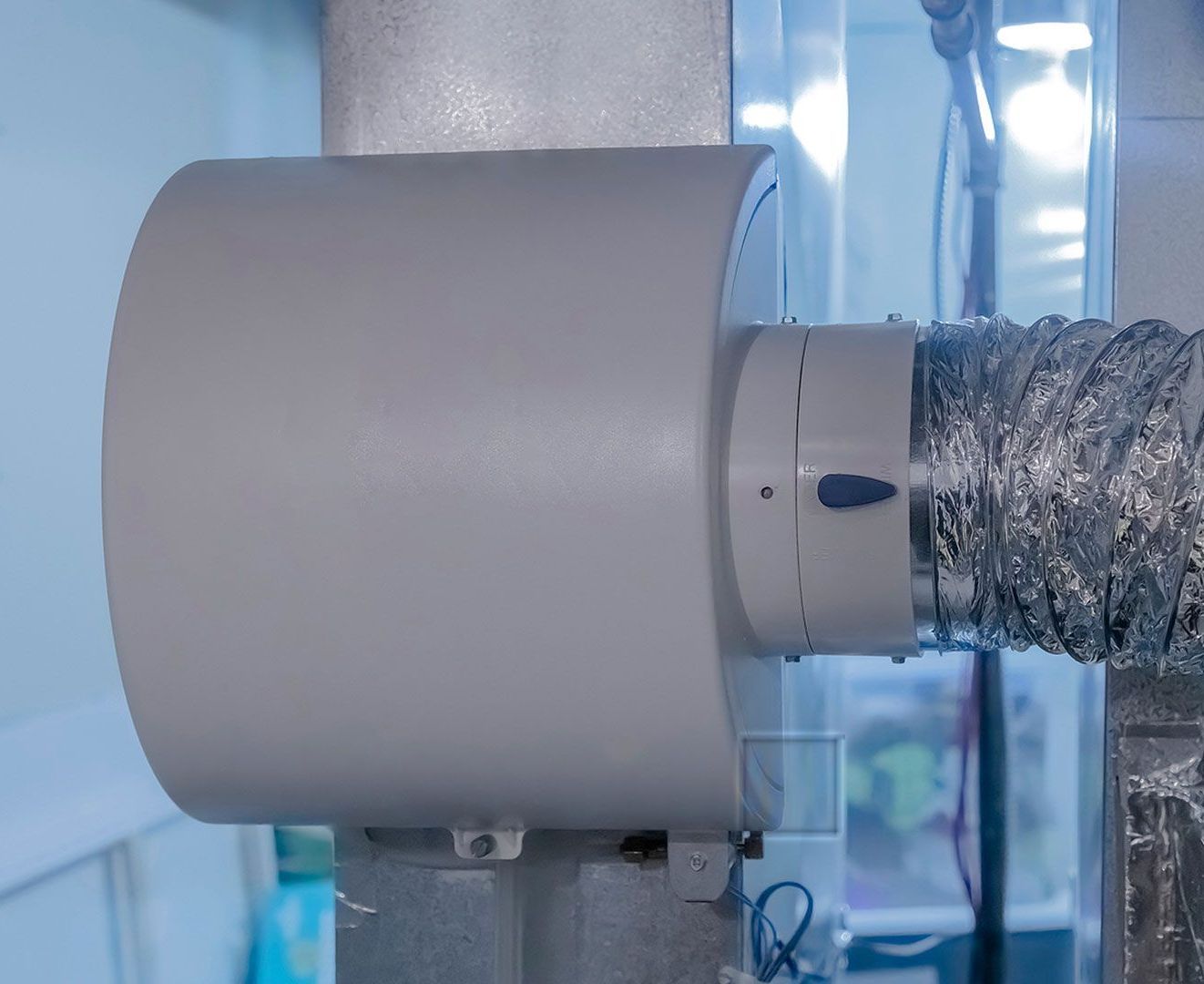 A close up of a fan attached to a pipe in a room.