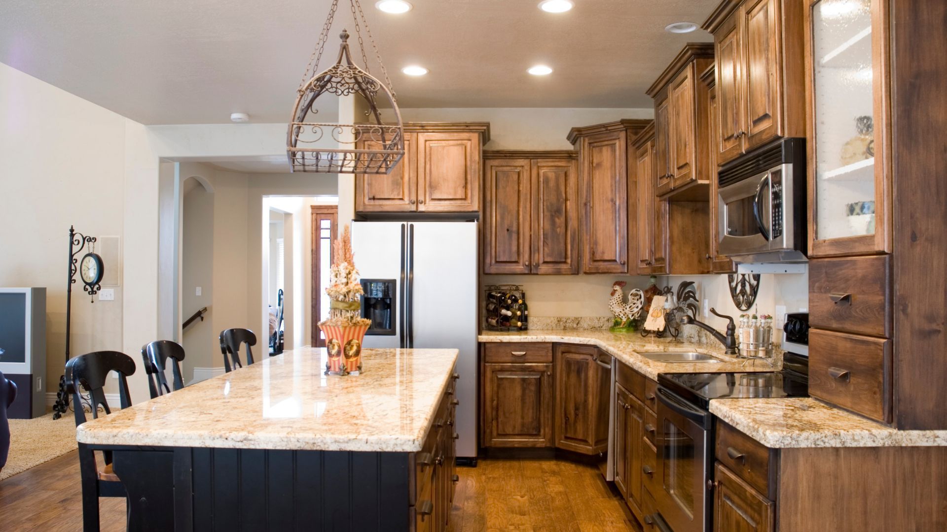 Modern kitchen with wooden cabinets, granite countertops, and stainless steel appliances in Athens.