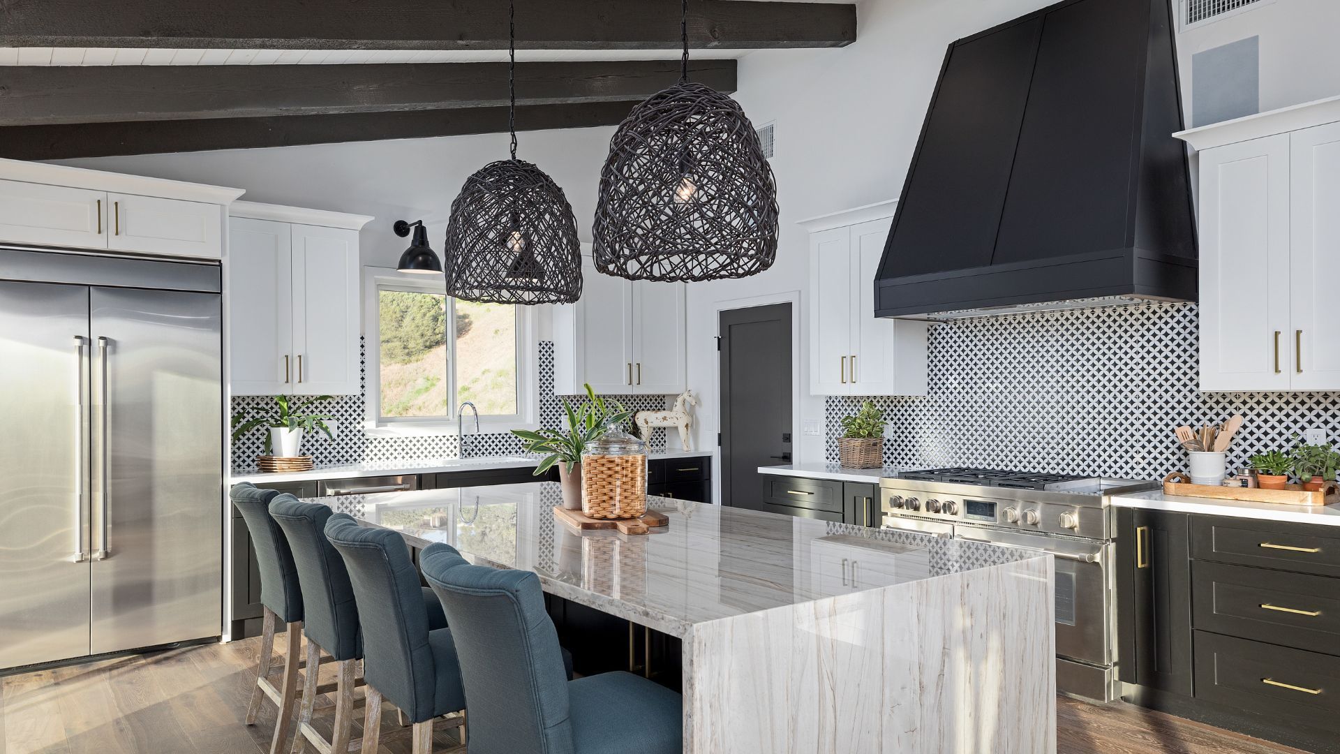 Modern kitchen with white cabinets, marble island, and unique black wicker lights.