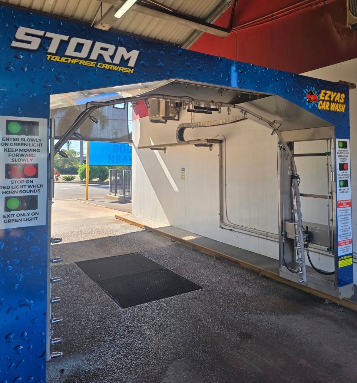 Blue STORM car wash entrance with open wash bay and cleaning equipment under a canopy — Ezyas Car Wash NT in Yarrawonga, NT