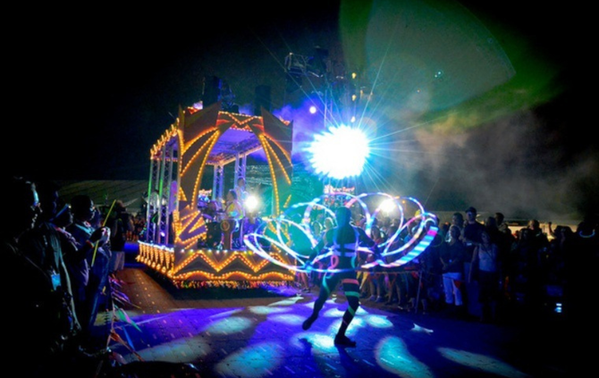 A group of people are standing in front of a stage at a concert.