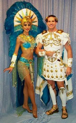 Woman in turquoise costume and man in Roman armor pose together.