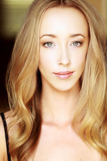 Blonde woman with light skin and blue eyes looking at the camera.