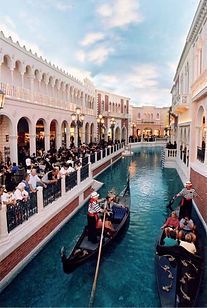 A group of people are riding a gondola down a canal.