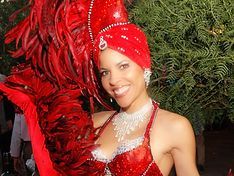 Woman in red carnival costume smiles.