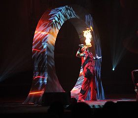 A person is holding a torch in their hand on a stage.