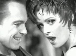 A man and a woman are looking at each other in a black and white photo.