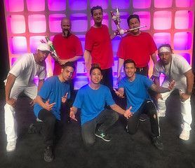 A group of men in red shirts and blue shirts are posing for a picture.