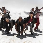 Group of diverse dancers in an outdoor setting, performing a dynamic, choreographed movement.