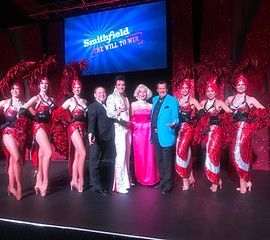 A group of people are posing for a picture on a stage.