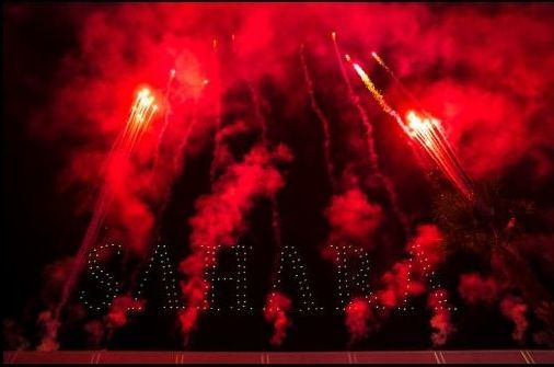 Red fireworks explode, illuminating