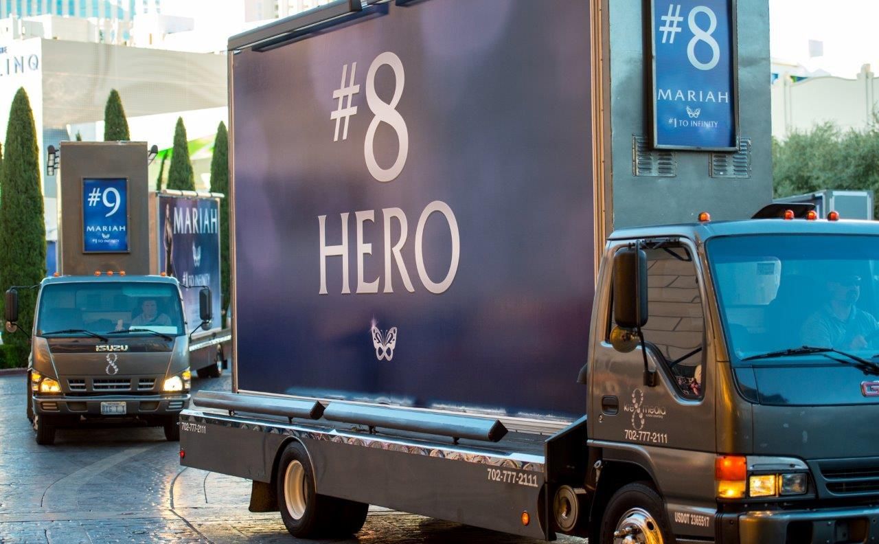 Two trucks with billboard signs: