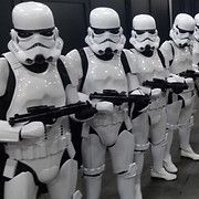 Stormtroopers, in white armor, line up holding blasters.