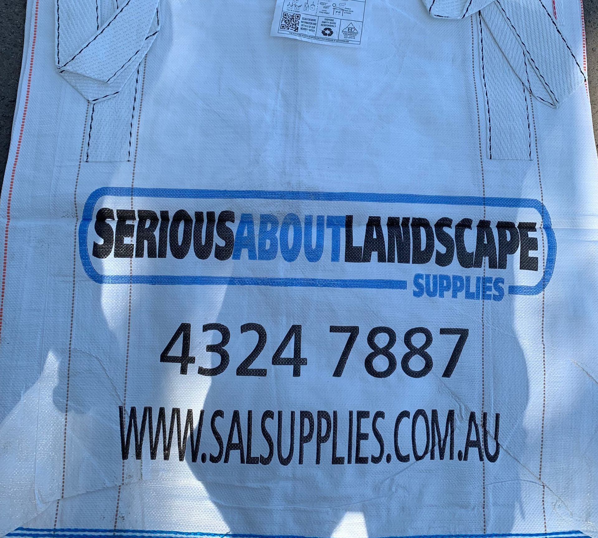 A Row Of White Bags Sitting On The Side Of A Road — Serious About Landscape Supplies In West Gosford, NSW