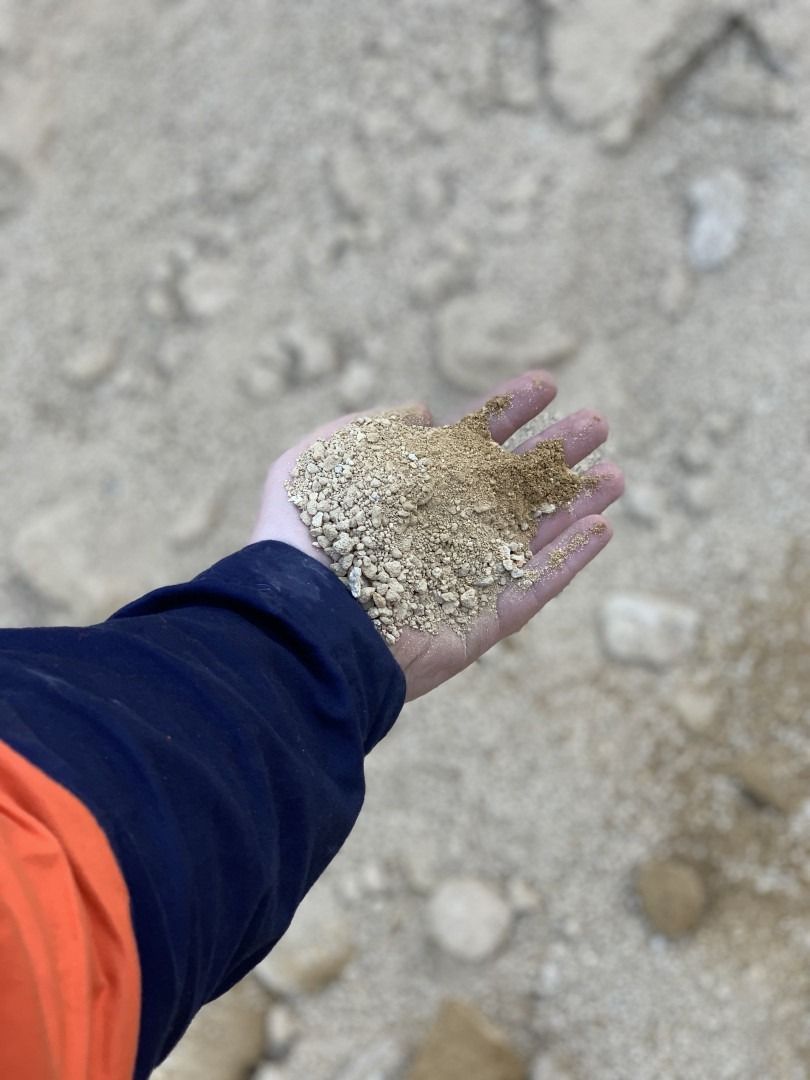 A Person Is Holding A Pile Of Sand In Their Hand — Serious About Landscape Supplies In West Gosford, NSW