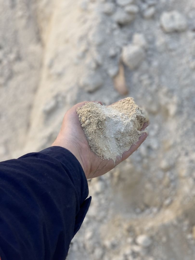 A Person Is Holding A Pile Of Sand In Their Hand — Serious About Landscape Supplies In West Gosford, NSW