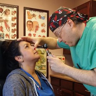 Image of Dr. Erik inspecting a patients nasal cavity in his Laredo, TX office