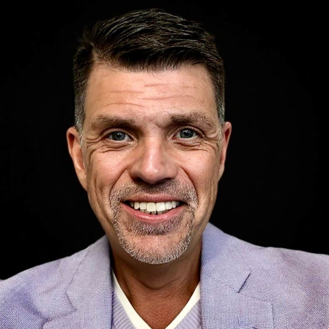 A woman with long hair and earrings is smiling for the camera.