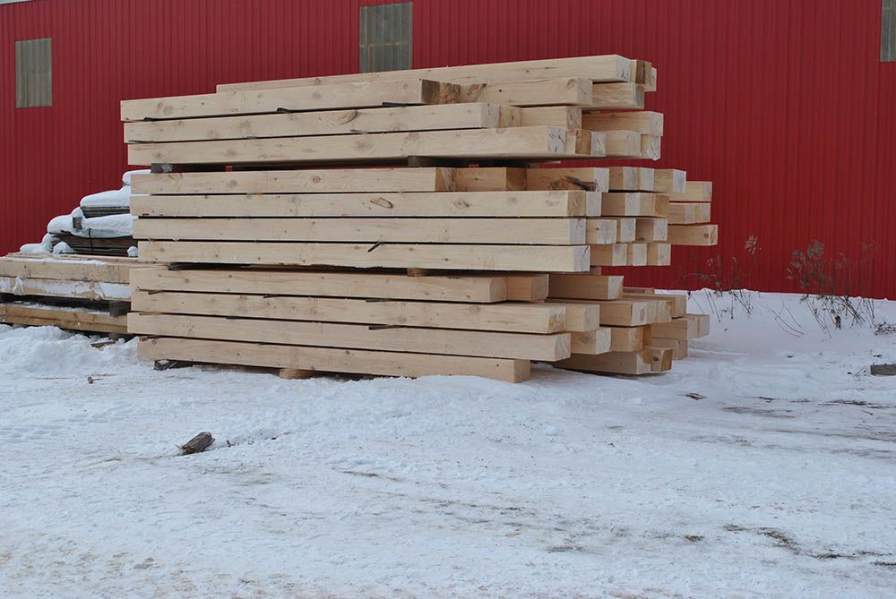 stacks of pine wood sitting on the snow