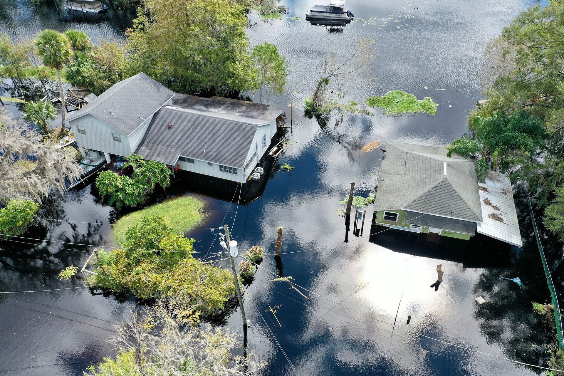 An aerial view of a flooded area with houses and trees