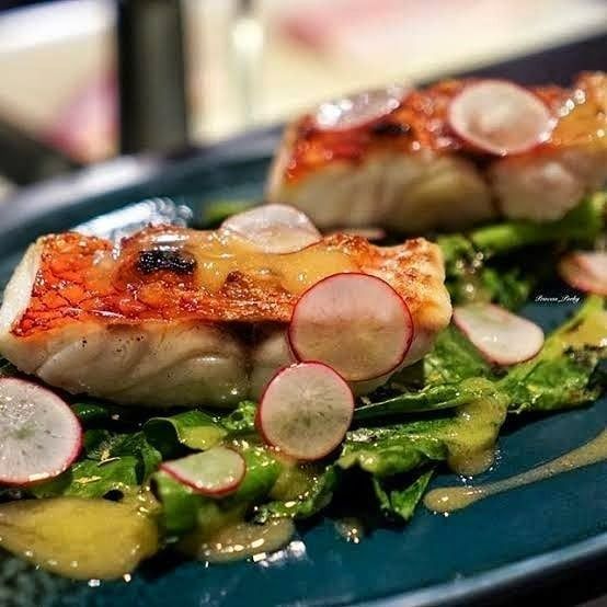 A Close Up of a Plate of Food With Radishes and Lettuce on a Table — Noosa Junction Seafood Market in Noosa Heads, QLD