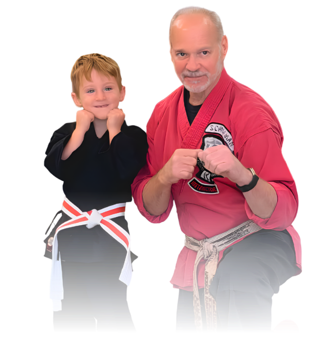 Man pointing, smiling, wearing black hoodie; arm tattoo visible.