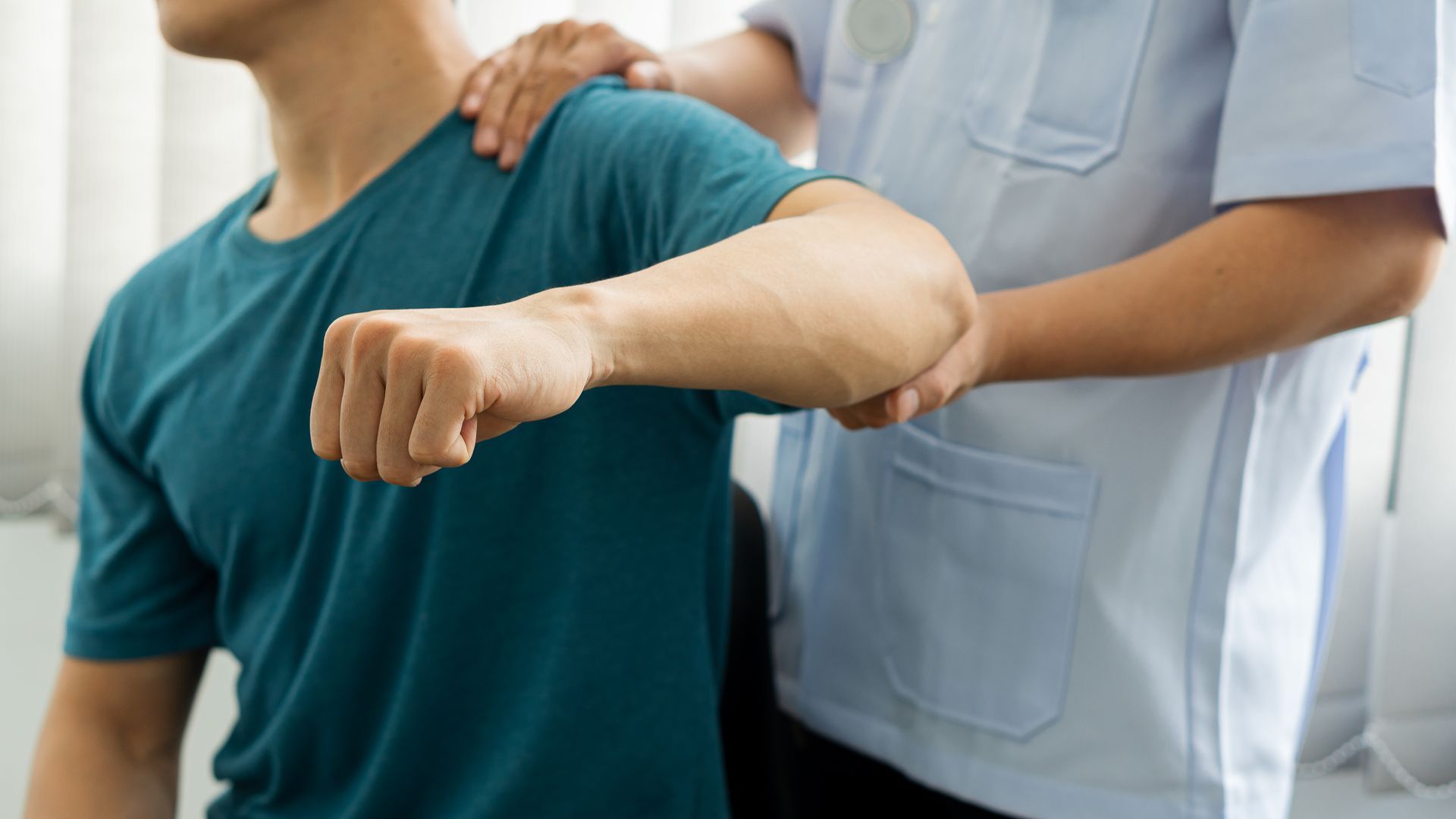 A man is getting his shoulder examined by a doctor.