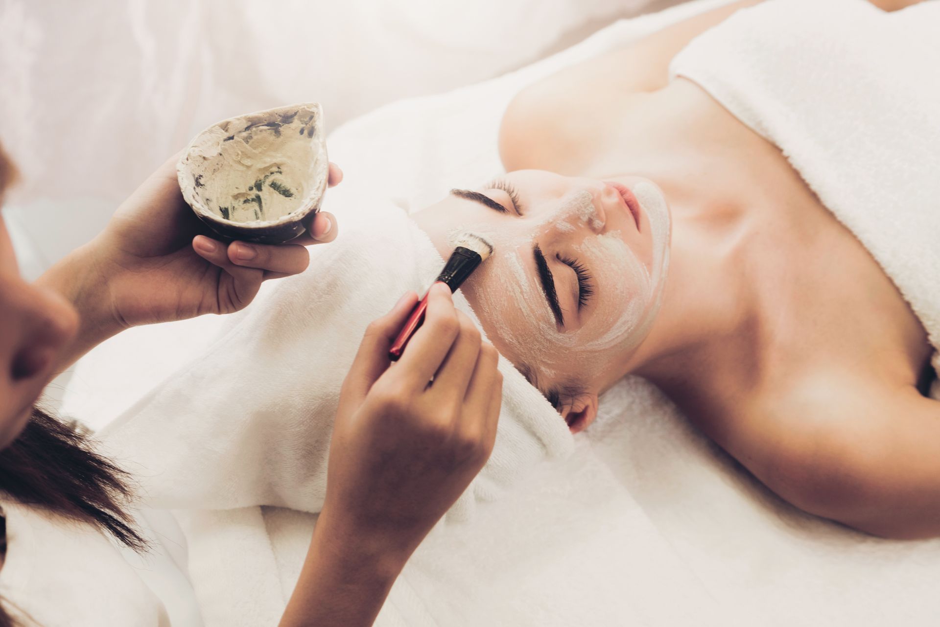 A woman is getting a facial treatment at a spa.