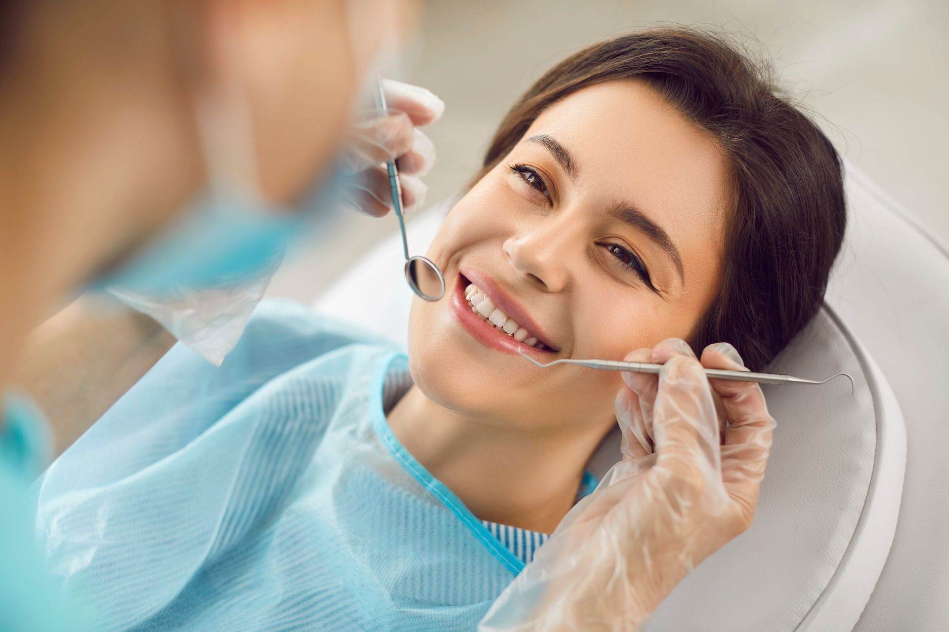 A woman is having her teeth examined by a dentist.