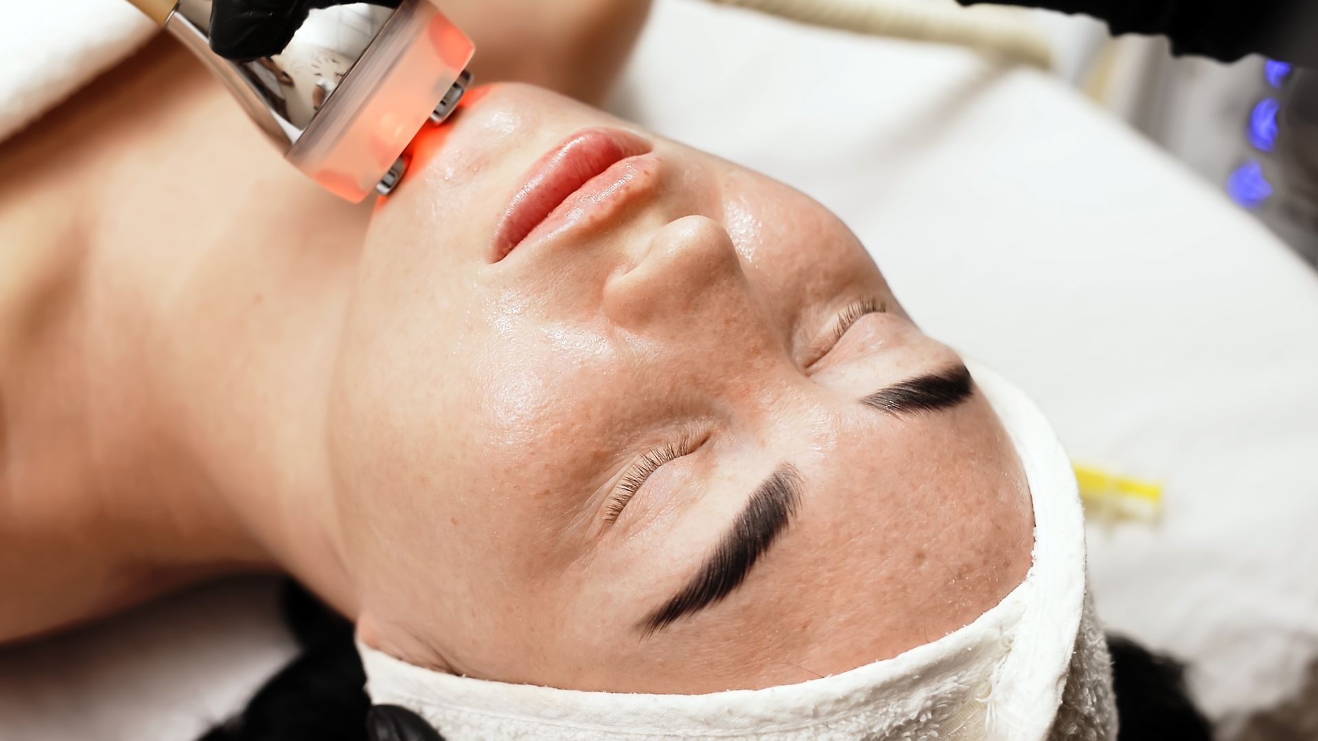 A woman is getting a laser treatment on her face.