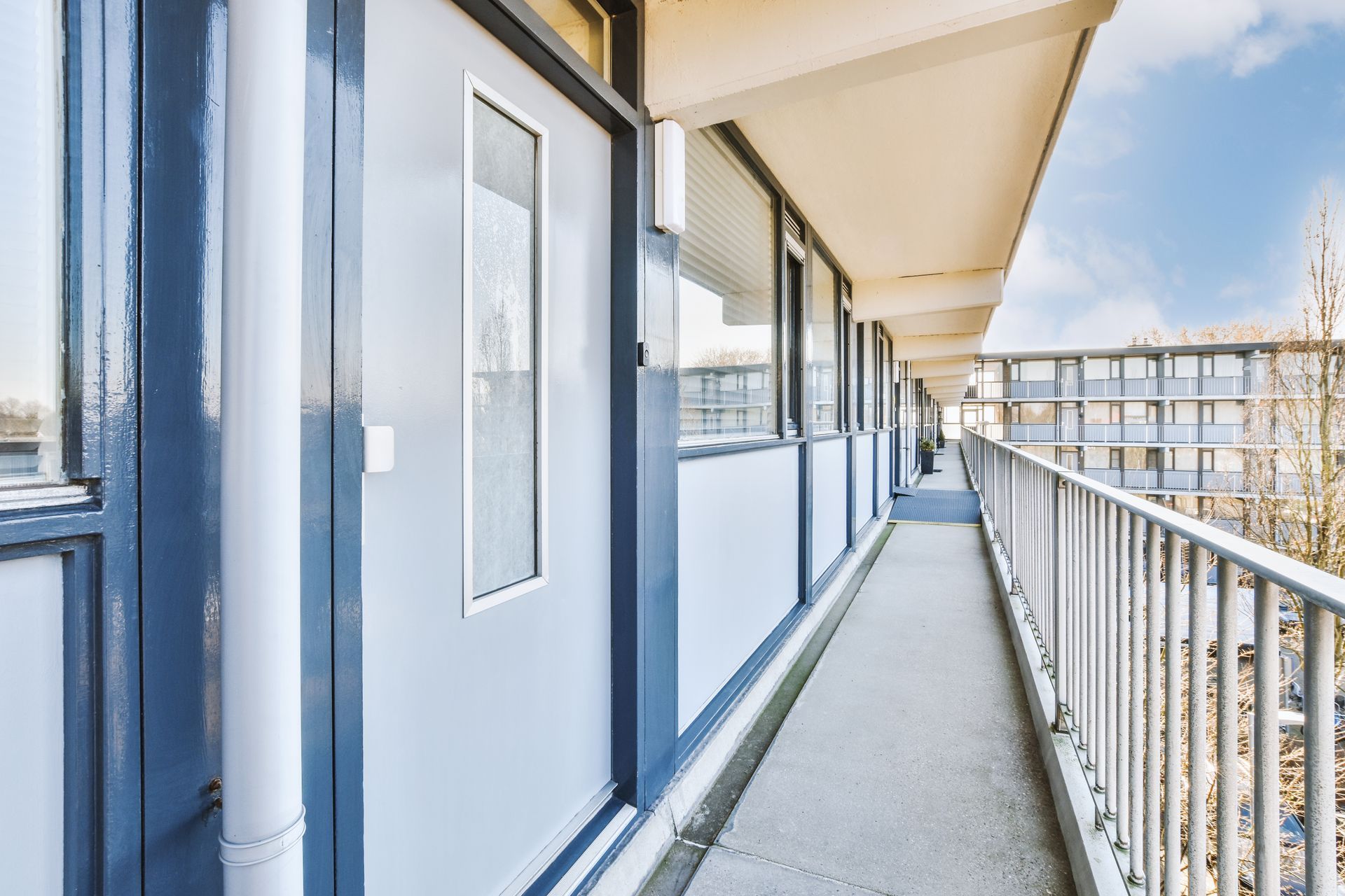 A hallway in a building with a balcony and a railing