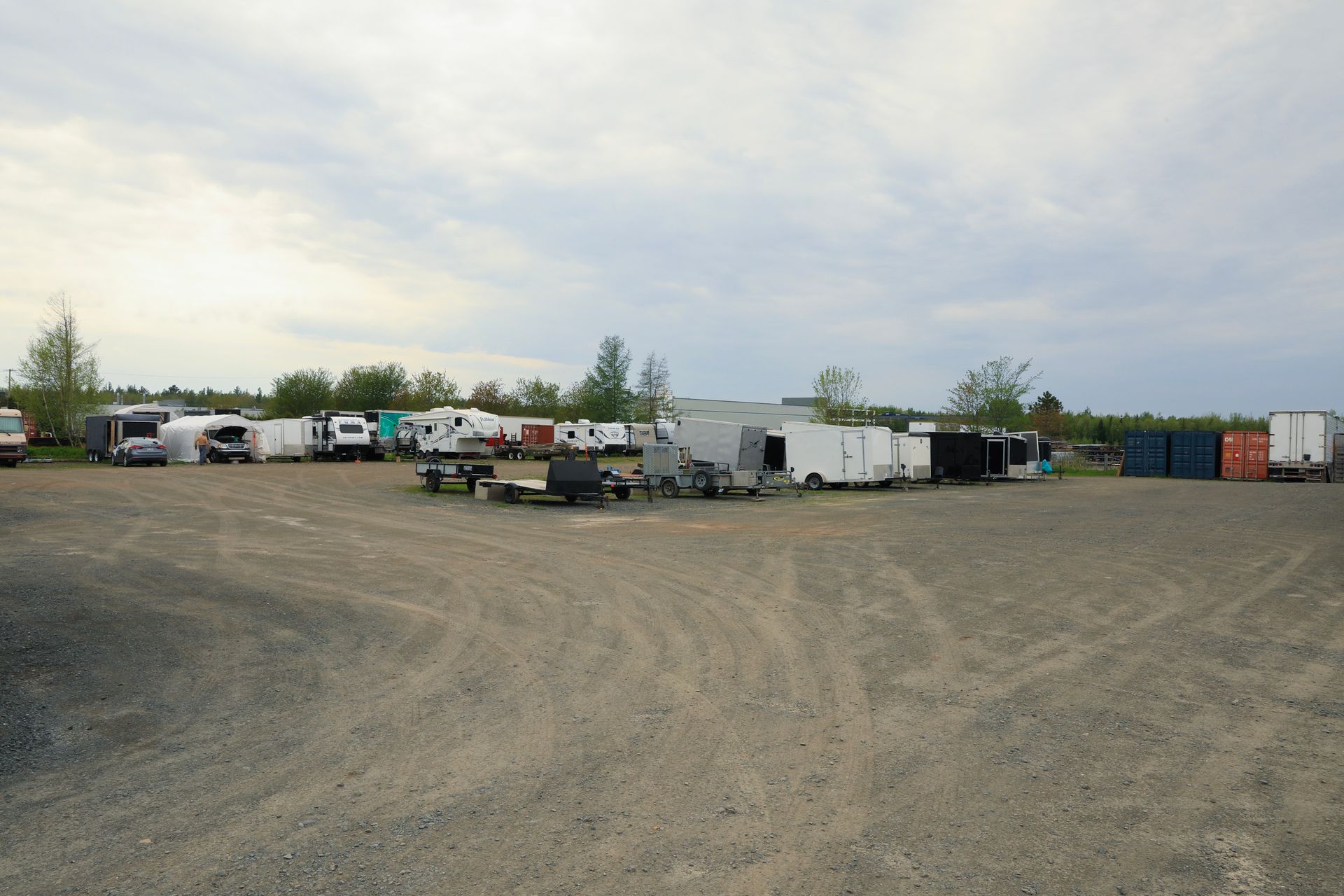 Beaucoup de remorques sont garées sur un terrain en gravier
